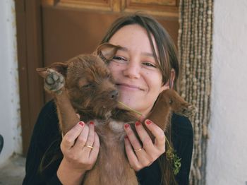 Portrait of young woman holding dog