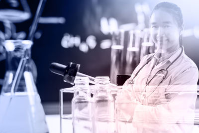 Digital composite image of female scientist standing at laboratory