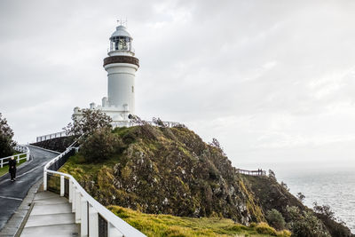 Lighthouse by sea against sky