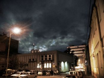 Cars on road against cloudy sky