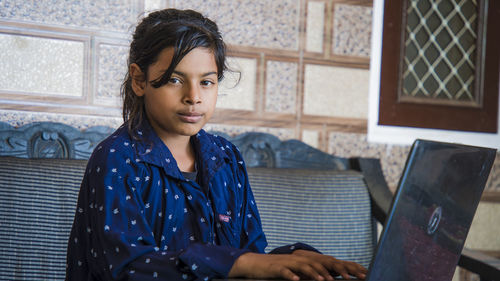 Portrait of girl using laptop at home