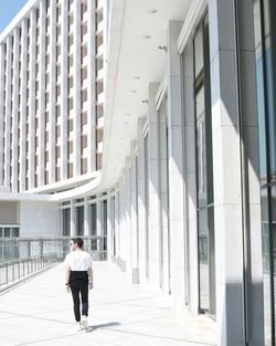 Rear view of man walking in corridor of building