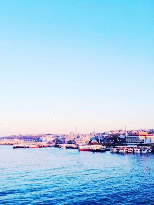 water, nautical vessel, clear sky, copy space, waterfront, transportation, sea, mode of transport, boat, building exterior, built structure, blue, architecture, moored, harbor, nature, outdoors, tranquility, tranquil scene, rippled