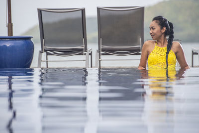 Beautiful woman enjoying a relaxing time in the pool of luxury resort