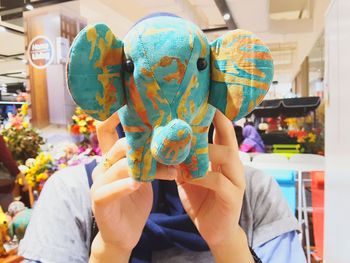 Woman holding elephant shape toy in shop