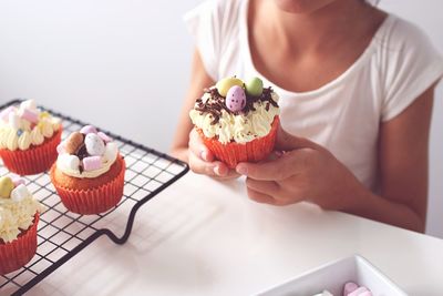 Close-up of hands holding cupcake on table