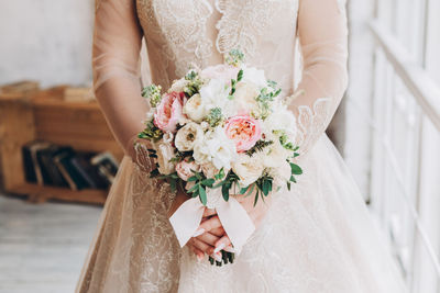 Midsection of woman holding flower bouquet