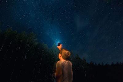 Rear view of woman standing against star field