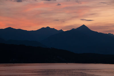 Scenic view of silhouette mountains against orange sky