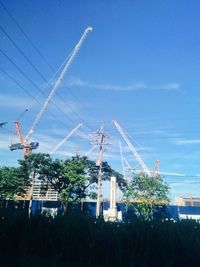 Cranes at construction site against sky