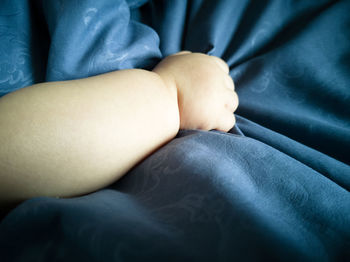 Low section of man lying on bed