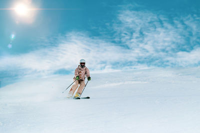 Person walking on snow covered mountain against sky