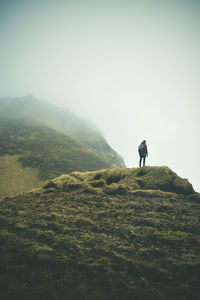 Man standing on mountain against sky