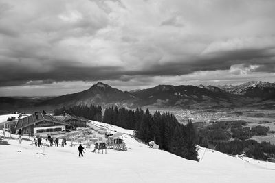 People on snowcapped mountains against sky
