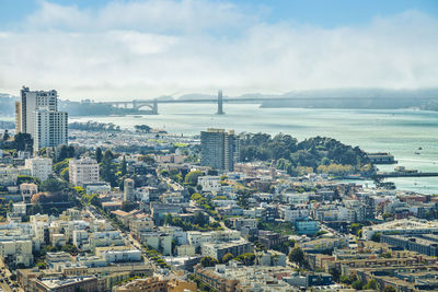 Cityscape by sea against sky