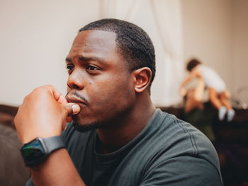 Close-up of man looking away while sitting at home