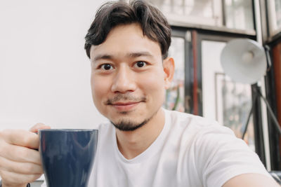 Close-up portrait of young man drinking glasses