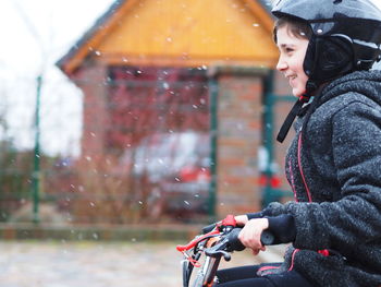 Side view of smiling woman riding motorcycle in rain