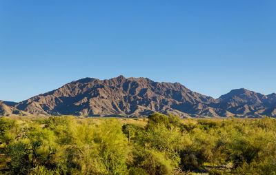 Scenic view of mountains against clear blue sky