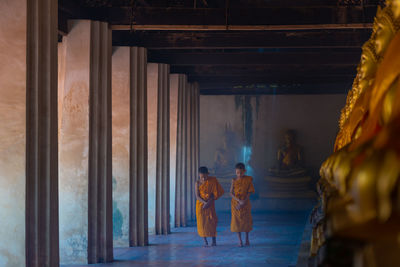 Rear view of men outside temple in building
