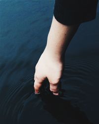 Close-up of hand touching water