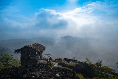 Hut by building against sky