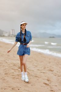 Portrait of young woman standing at beach