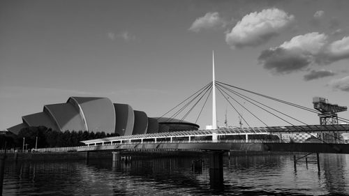 Bridge over river against sky in city