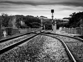 Railroad tracks by trees against sky