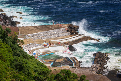 People by a seawater swimming pool foz da ribeira do guilherme on sao miguel island, azores