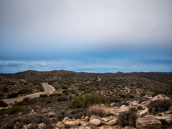 Desert landscape with roadway under cloudy skies