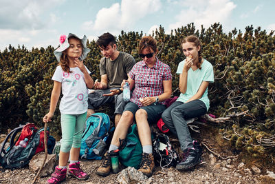 Family having break and eating snacks during trip in mountains. family actively spending vacation