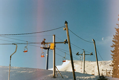 Scenic view on empty ski lifts against the moon in the sky during sunrise