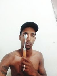 Portrait of a young man making face against white background