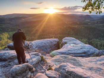 Photographer prepare camera to takes impressive photos. tourist at sharp rocky edge on high view