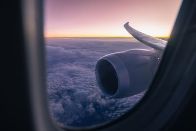 Beautiful view from airplane window over jet engine and wing. plane flying high above clouds.