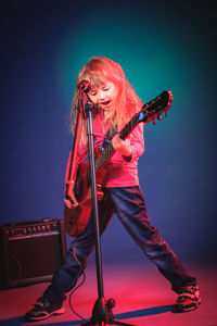 Girl playing guitar on stage