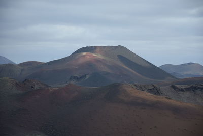 View of volcanic land against sky