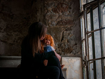 Mother and daughter against wall