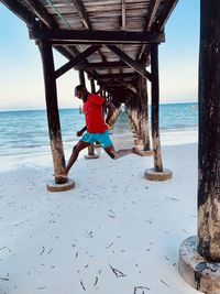 Rear view of woman standing at beach