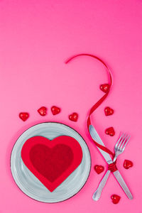 Directly above shot of heart shape on pink table