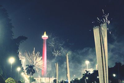 Low angle view of fireworks against sky at night