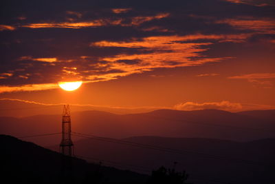 Silhouette mountains against orange sky