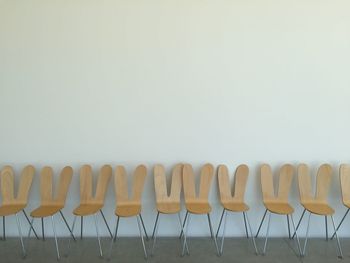 Wooden chairs arranged against wall