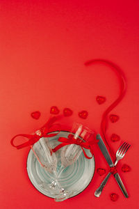 High angle view of red glass against colored background