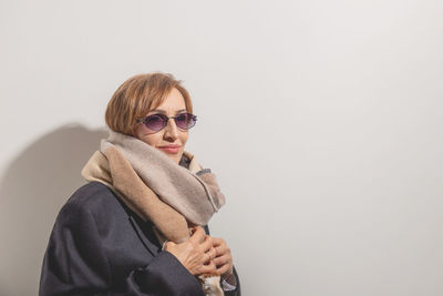 Young woman wearing sunglasses against white background