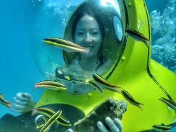 Happy young woman swimming underwater with scuba mask