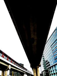 Low angle view of bridge against buildings in city