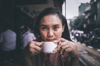 Portrait of man drinking coffee in cafe