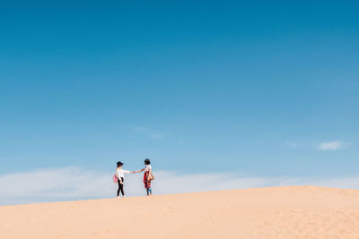 People on desert against sky